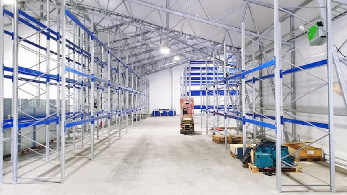 Insidan av en rymlig täIthall med metallhyllor, byggd av Hallgruppen, för lagring och organisation.